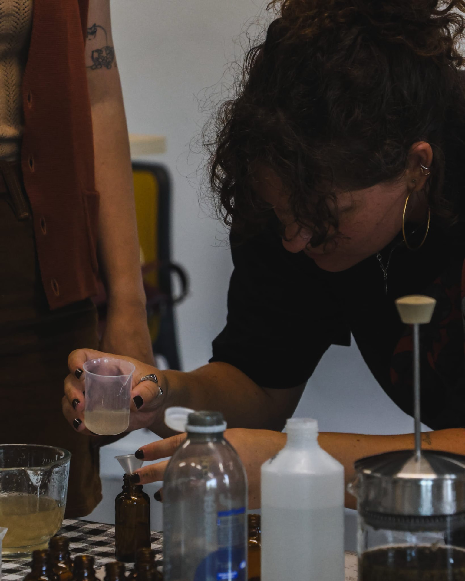 A workshop participant measuring a liquid at the shared making table